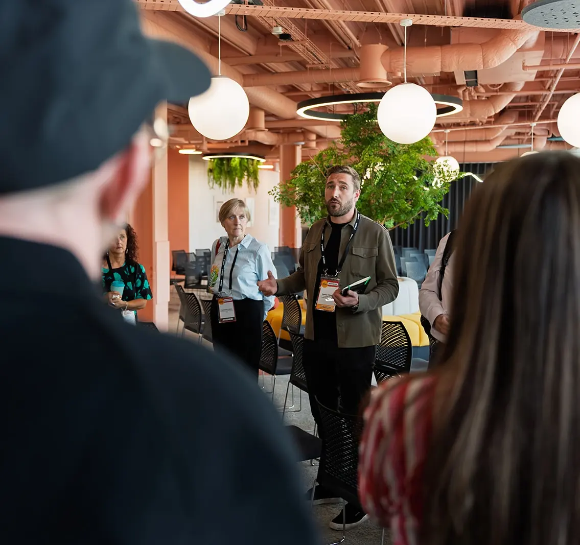 GCUC Manchester attendees discussing in a warm, plant-filled coworking event space